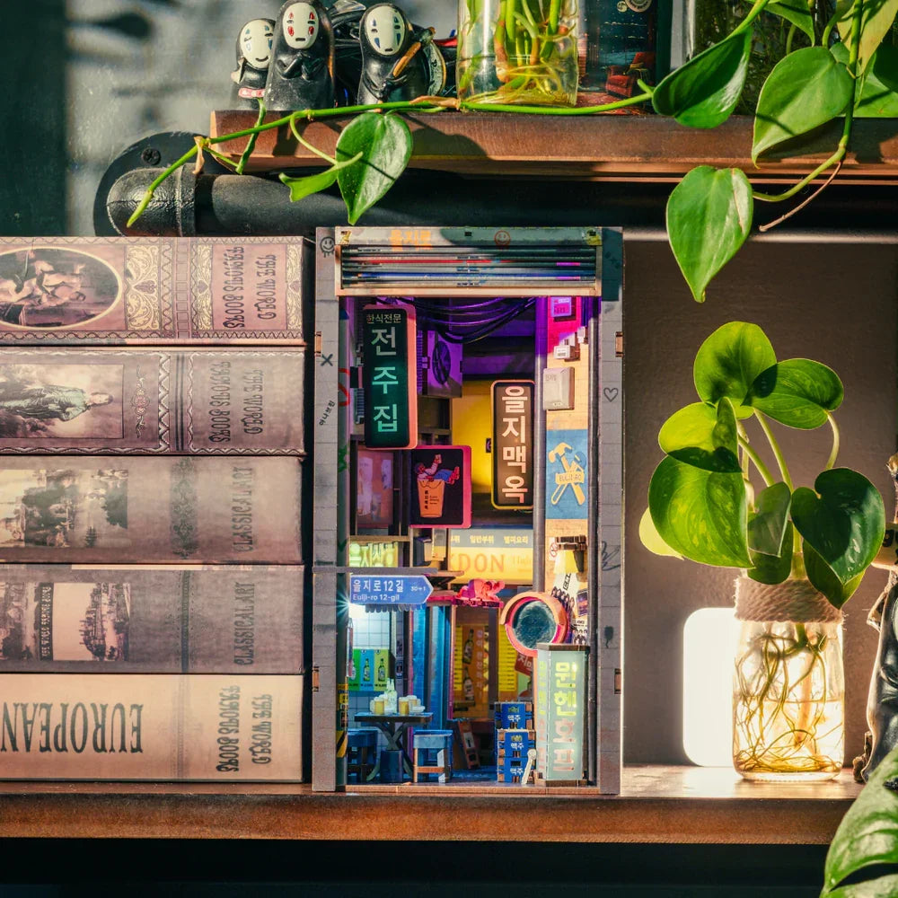 Miniatur-Diorama eines beleuchteten koreanischen Straßenzugs mit Büchern und Pflanzen