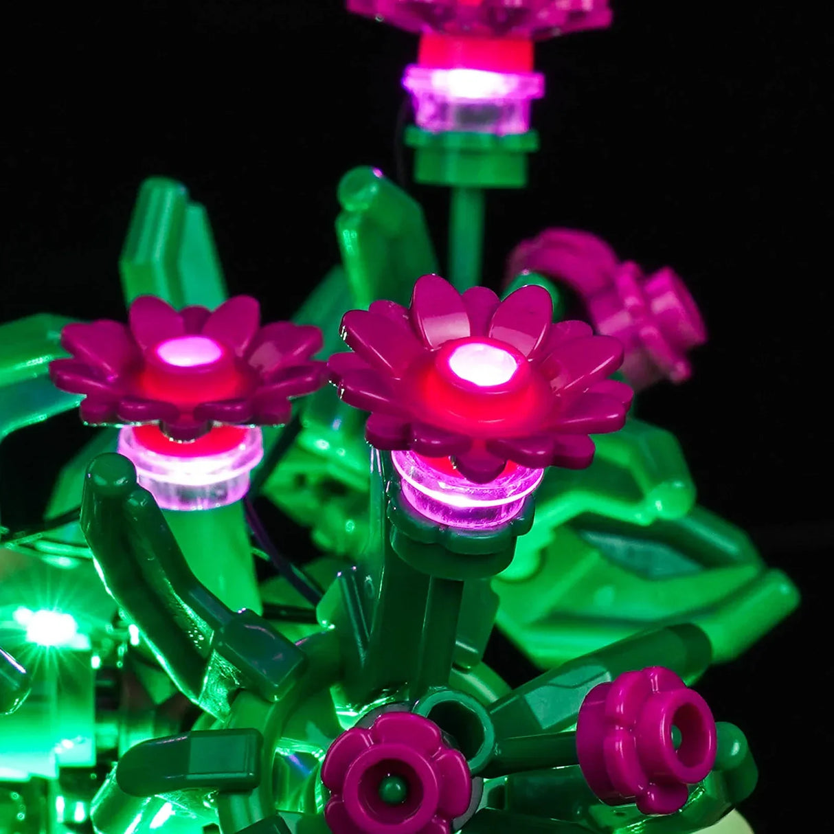 Nahaufnahme von pinken LEGO-Blumen, die durch ein integriertes LED-Lichtset von BrickBling hell leuchten.