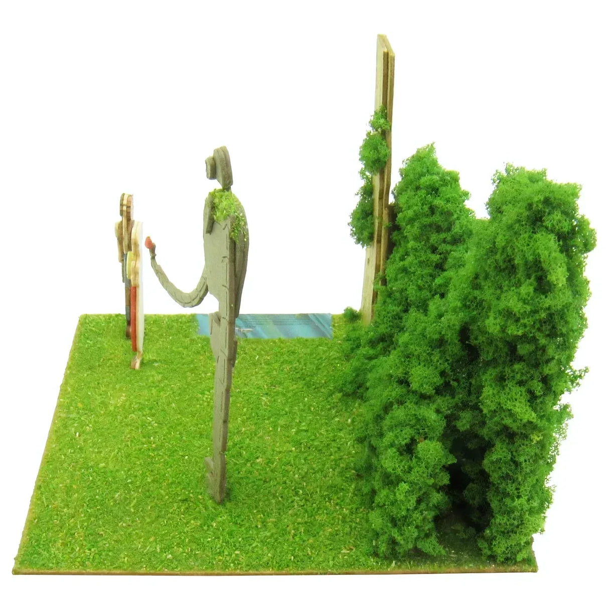 Modell einer Landschaft mit zwei Figuren, einem Baum und einem Busch auf grünem Gras