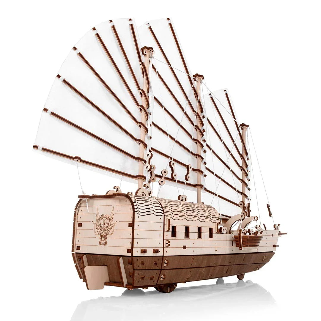 Modell eines Holzschiffs mit weißen Segeln und Drachenkopf am Heck