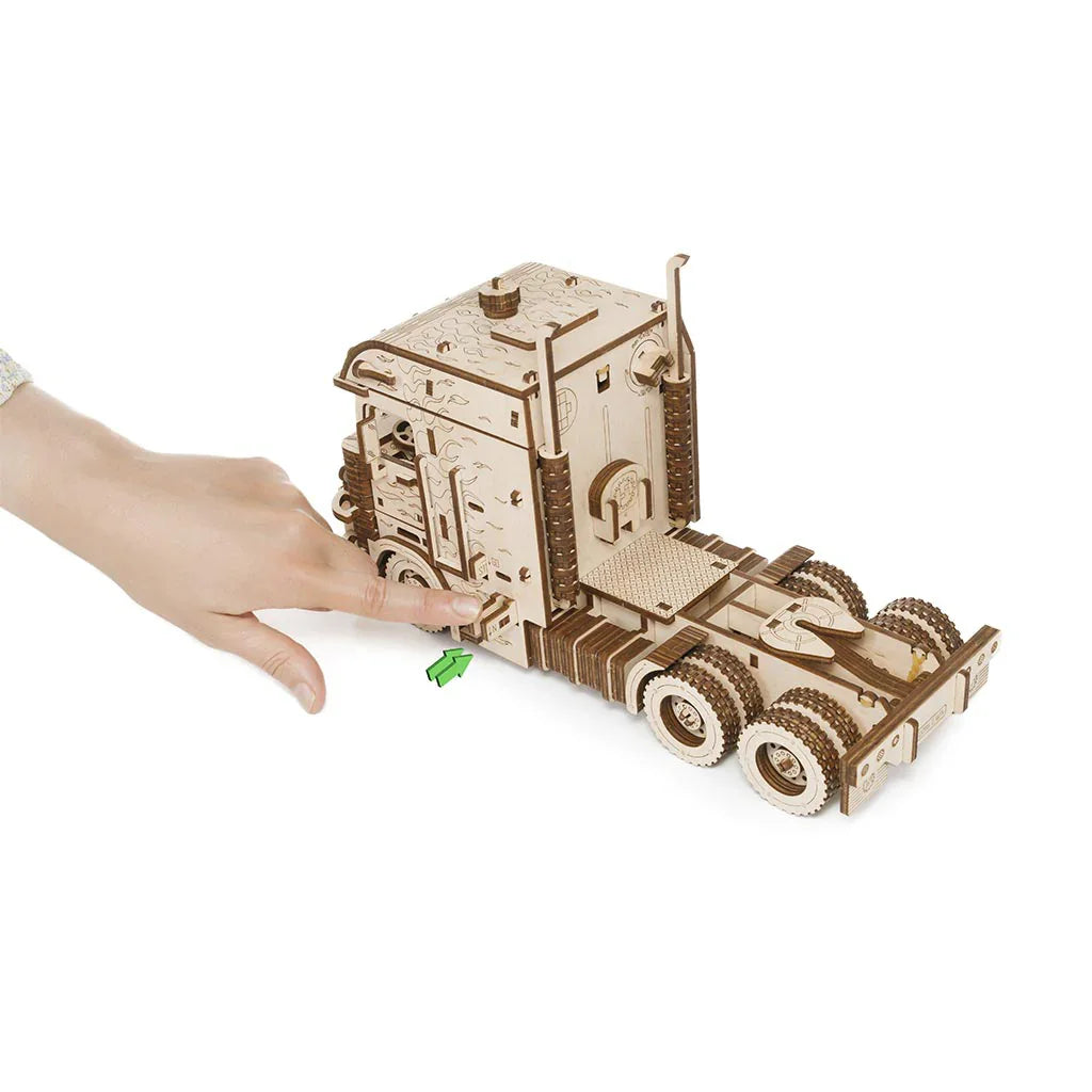 Hand drückt auf einen Holz-LKW-Bausatz
