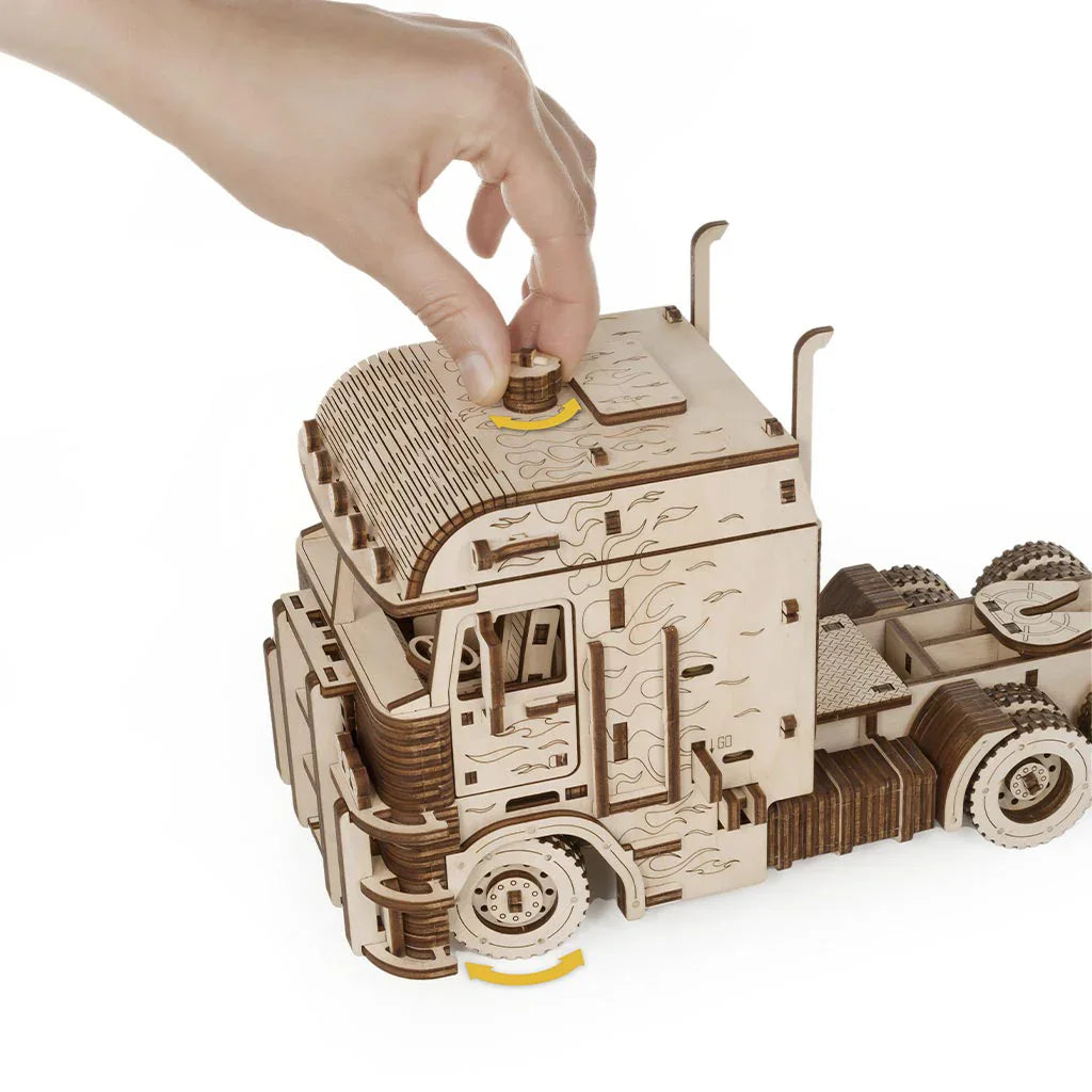 Hand dreht Rad an einem Holz-LKW-Modell