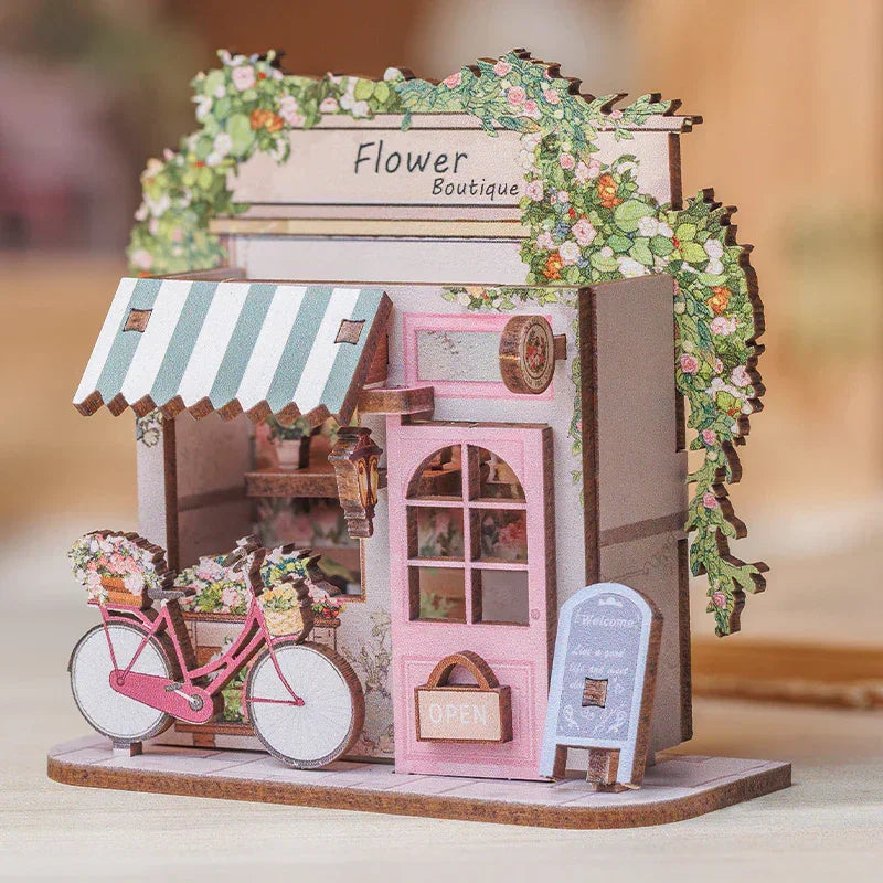 Miniatur-Blumenboutique mit rosa Fahrrad und Blumenkorb