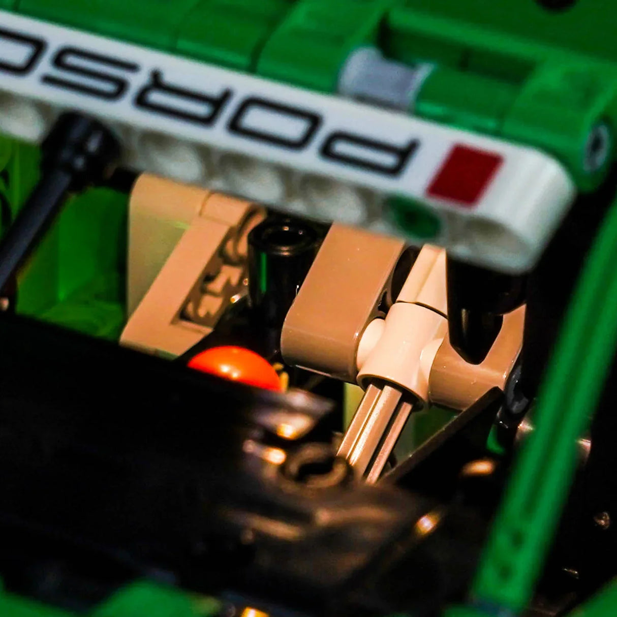 Nahaufnahme eines Lego Porsche Modells mit dem Porsche-Logo auf einem weißen Streifen