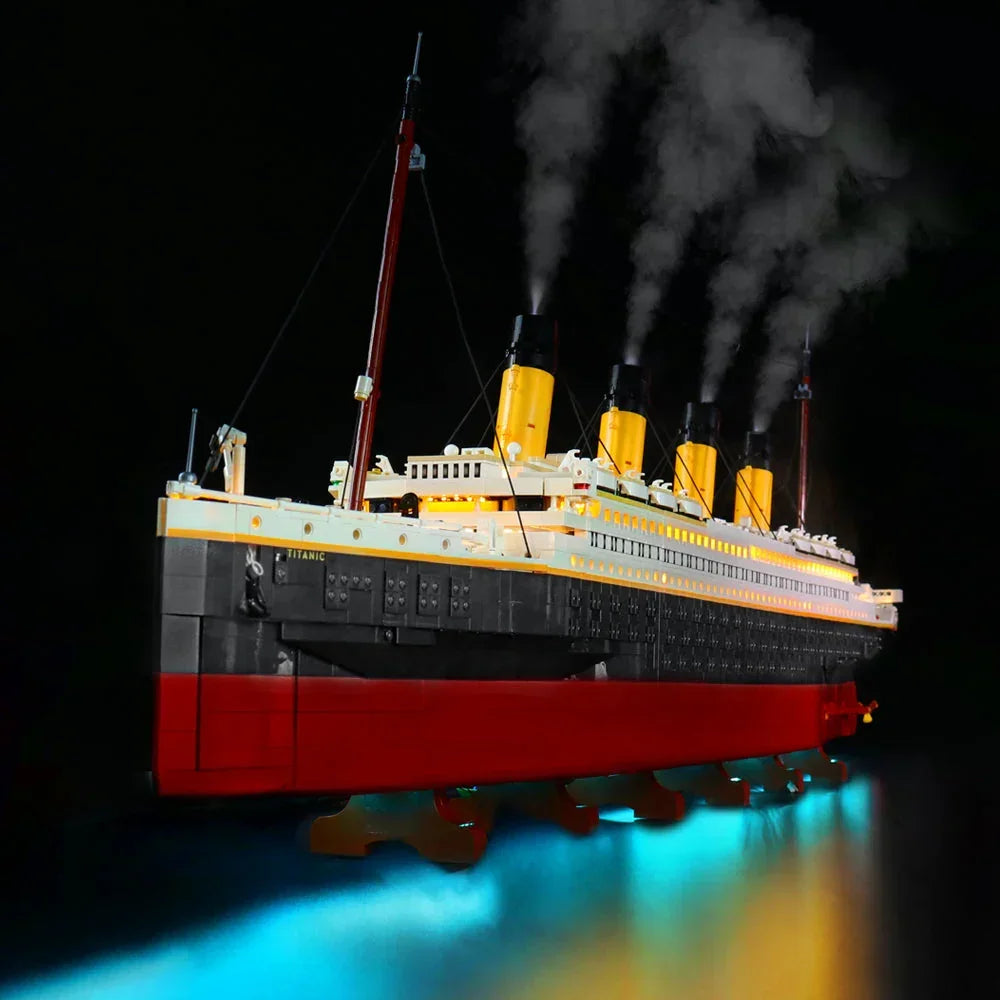 Frontale Perspektive des LEGO Titanic 10294 Luxusliners mit warmen LED-Lichtern in den Kabinen und einer blau schimmernden Rumpfbeleuchtung.