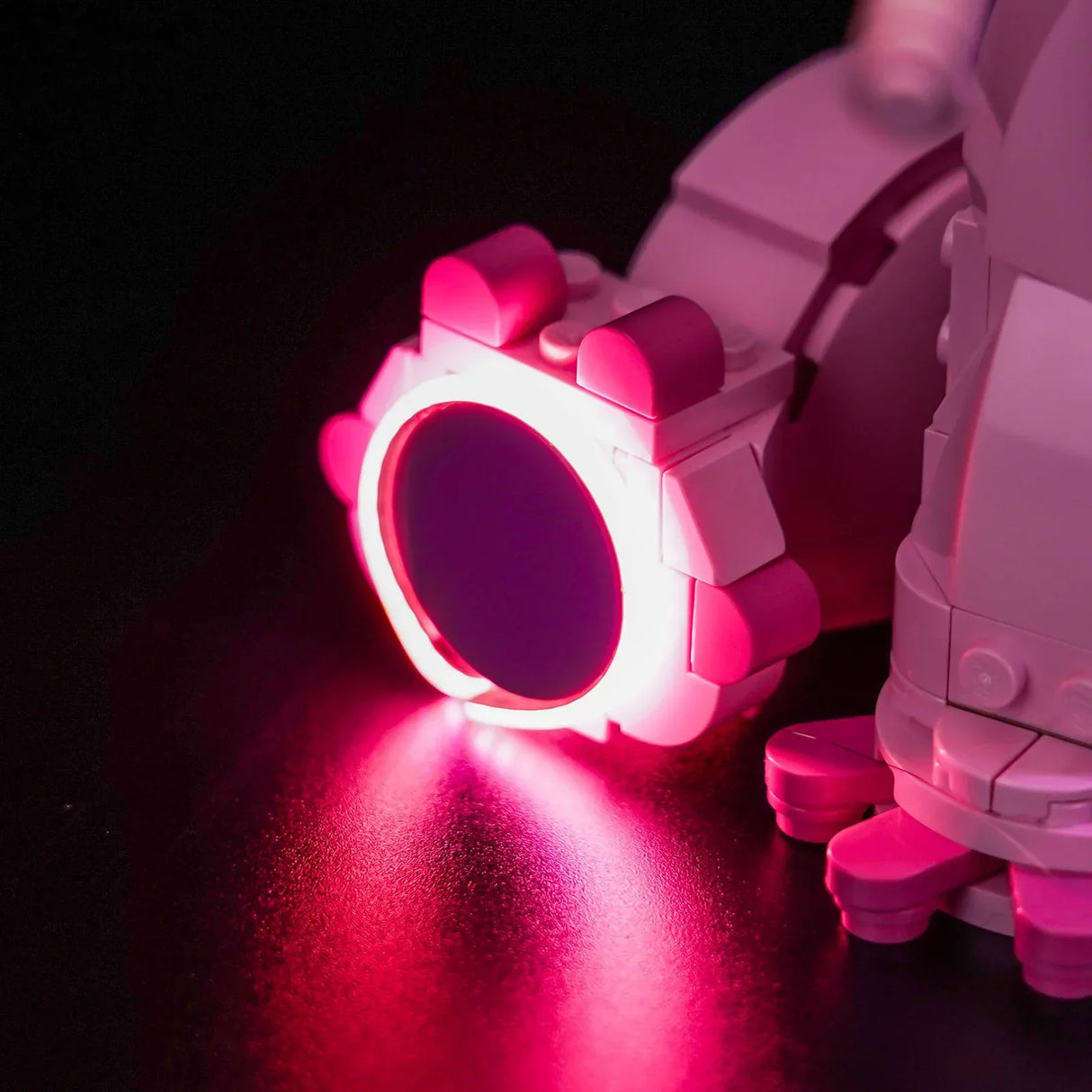 Nahaufnahme eines rosa und weißen Lego-Roboters mit leuchtenden rosa Lichtern