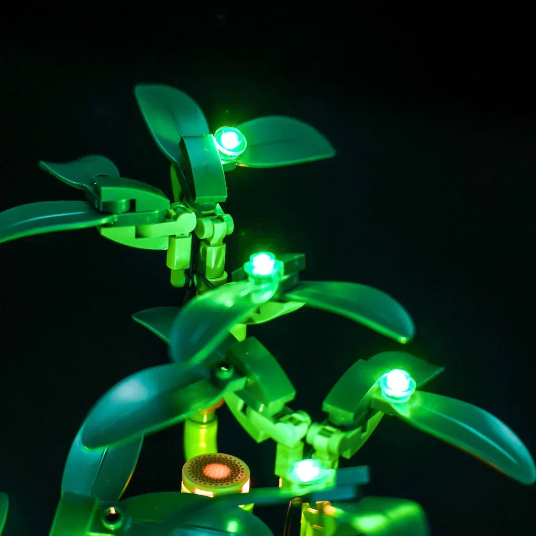 Nahaufnahme von grünen LEGO-Pflanzen mit leuchtenden grünen Lichtern auf schwarzem Hintergrund