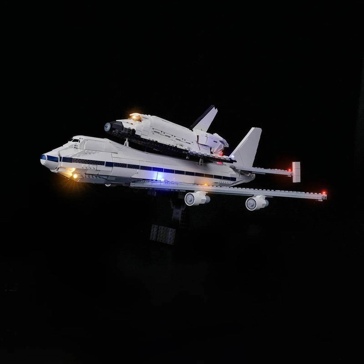 Beleuchtetes Modell eines Space Shuttles auf einem Flugzeugträger vor schwarzem Hintergrund