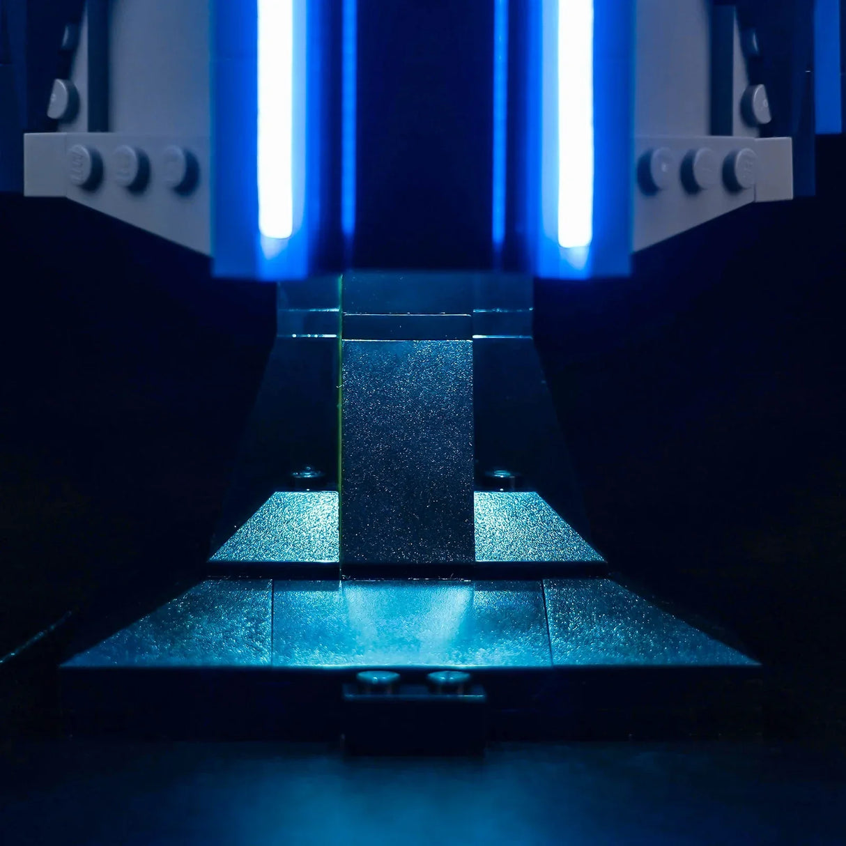 Nahaufnahme eines LEGO-Modells mit zwei vertikalen blauen Lichtstreifen und einer dunklen, strukturierten Basis