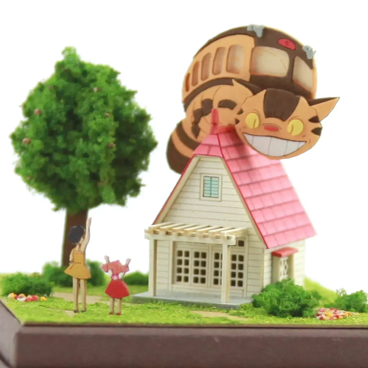 Modell eines Hauses mit rosa Dach, Baum, zwei Mädchen und Catbus-Figur auf dem Dach