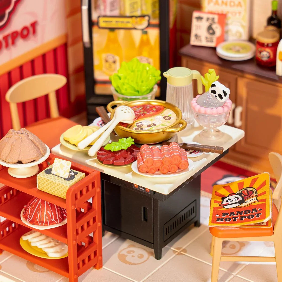 Miniatur-Hotpot-Set mit verschiedenen Zutaten, einem Topf und einem Panda-Dessert