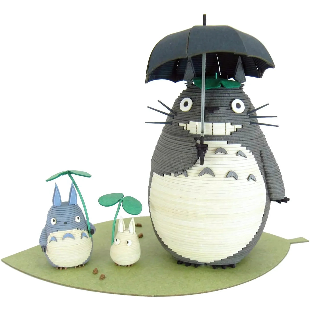 Totoro-Figuren aus Papier auf einem grünen Blatt, großer Totoro mit Regenschirm, kleinerer mit Blatt