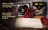 Produktübersicht des Wooden Trio Sets mit drei Holzplatten, roten Stoffbeuteln und der schwarzen Spielebox auf einer Holzoberfläche.