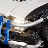 Nahaufnahme eines weißen und schwarzen Spielzeugautos mit leuchtenden Scheinwerfern und blauen und silbernen Details