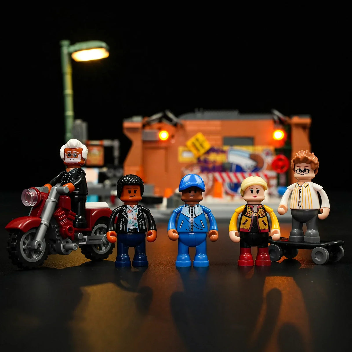 Fünf Lego-Figuren stehen vor einem beleuchteten Gebäude mit einer Straßenlaterne