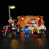 Fünf Lego-Figuren stehen vor einem beleuchteten Gebäude mit einer Straßenlaterne